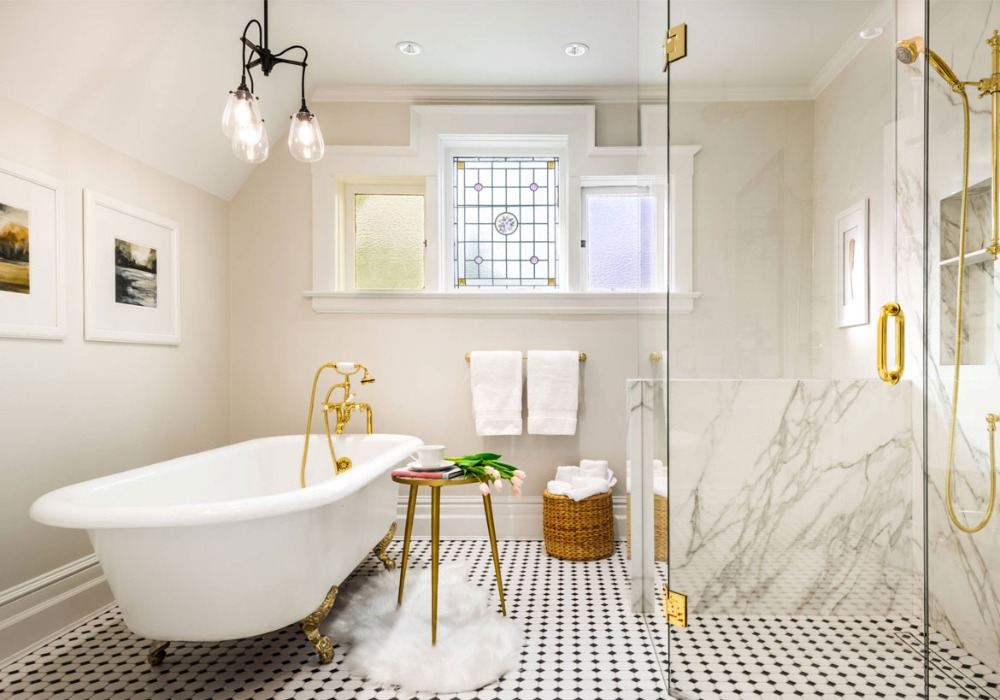 ädel badrumsdesign med gyllene element och marmorväggbeklädnad i duschkabin