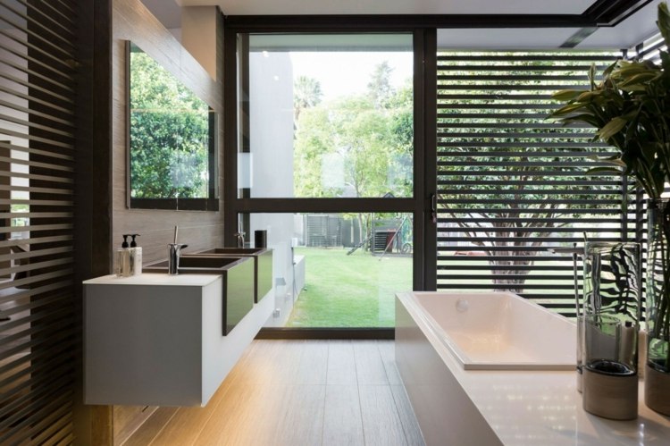 Badrumsdesign väggskåp inbyggt handfat trä persienner glasfronter