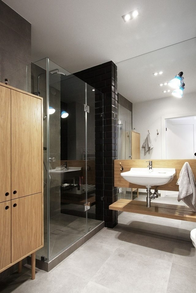 modernt-badrum-svart-kakel-dusch-område-trä-skåp