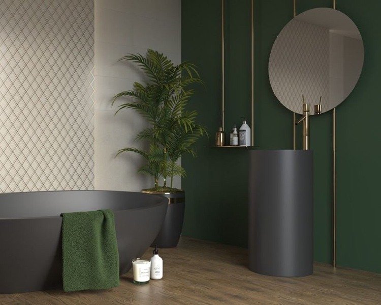 svart badkar och pelartvättställ framför en mörkgrön vägg