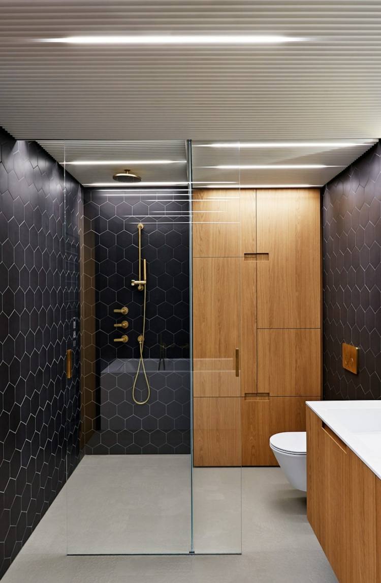lyxigt badrum i svartguld badrumsinredning brun sexkantskakel i trä
