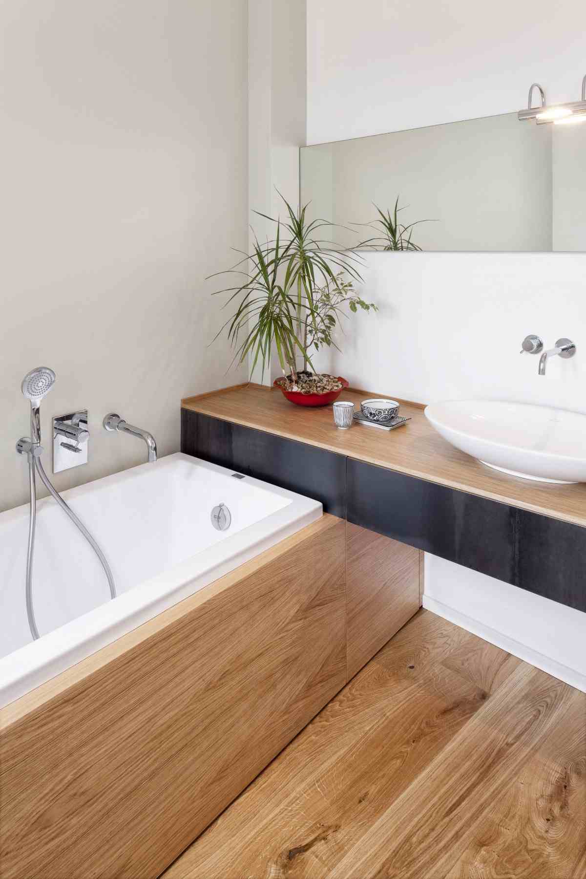 träbeklädnad som huvudelement i badrummet med badkar och handfat