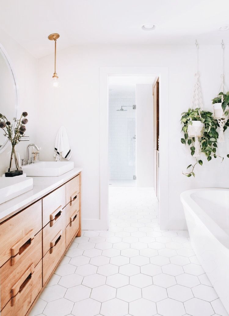 Underskåp av naturligt trä och sexkantiga plattor i badrummet i vit träkombination