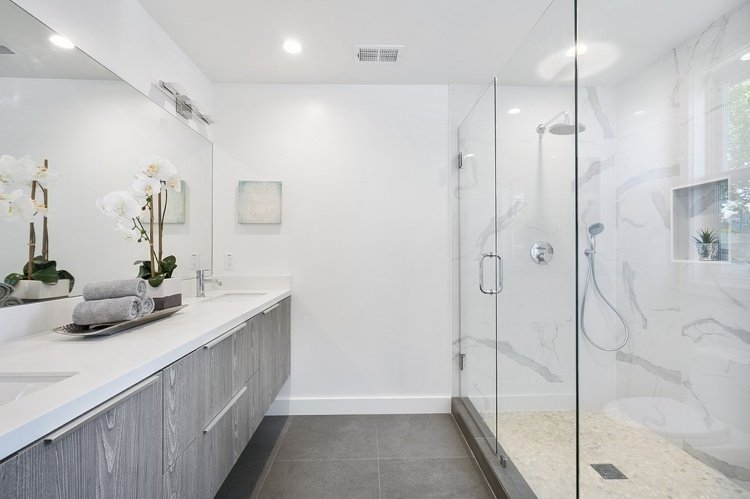 Badrumsrenovering med dubbla fåfänga i duschkabin i marmor