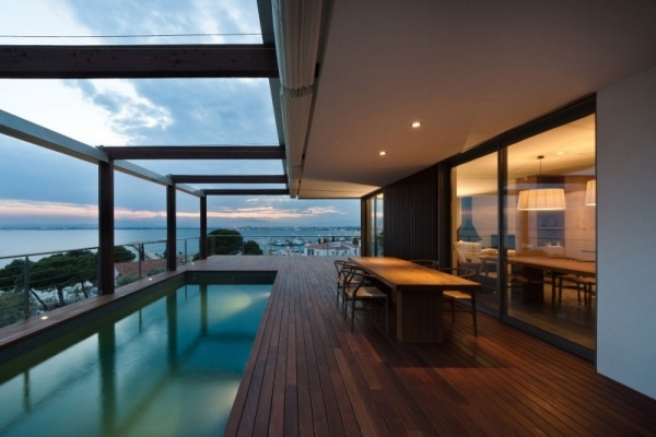 Modernt hus-med-balkong-pool-nedsänkt-i-marken-trädäck-sittgrupp
