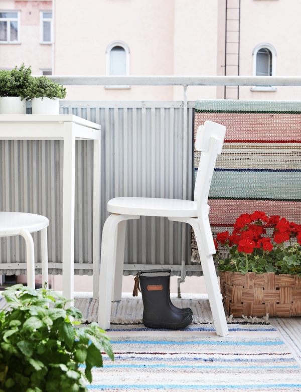 urban-balkong-möbler-skandinavisk stil-vit-stol-dörrmatta-ränder-blomkrukor