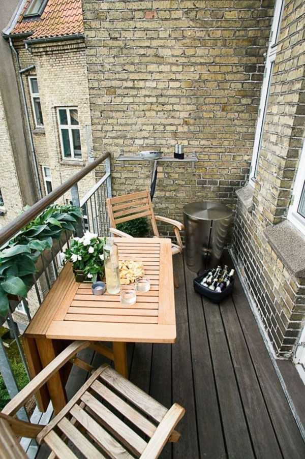 Balkong-möbler-fällbara stolar i teak-soffbord-metallräcken-blomsterdekoration