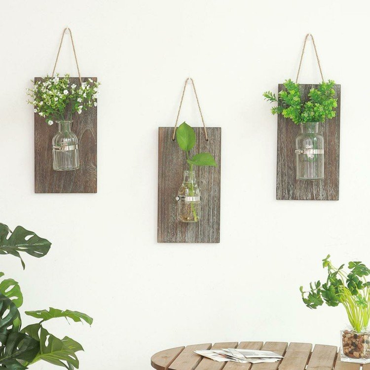 DIY -idé med brädor och glasflaskor som vaser för väggen