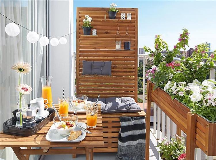 Vita liljor i kruka balkong rottingfåtölj färgglada kuddar fällbara bord