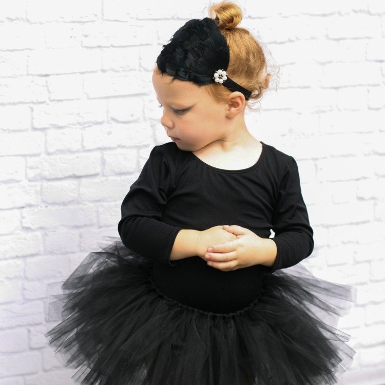 svart ballerinakostym med fascinator som hårprydnad