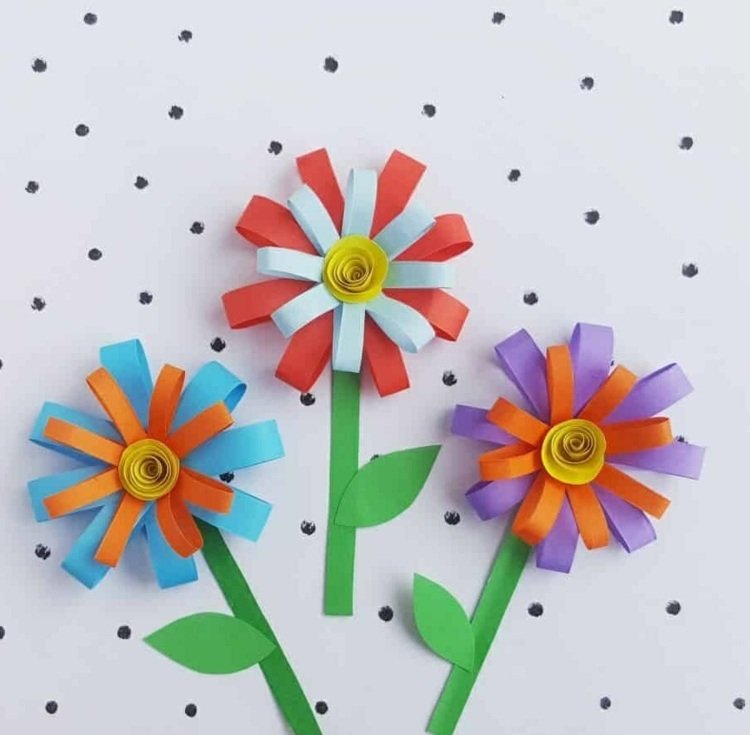 Hantverk med barn på våren och blommor från pappersremsor i ljusa färger - krysantemum
