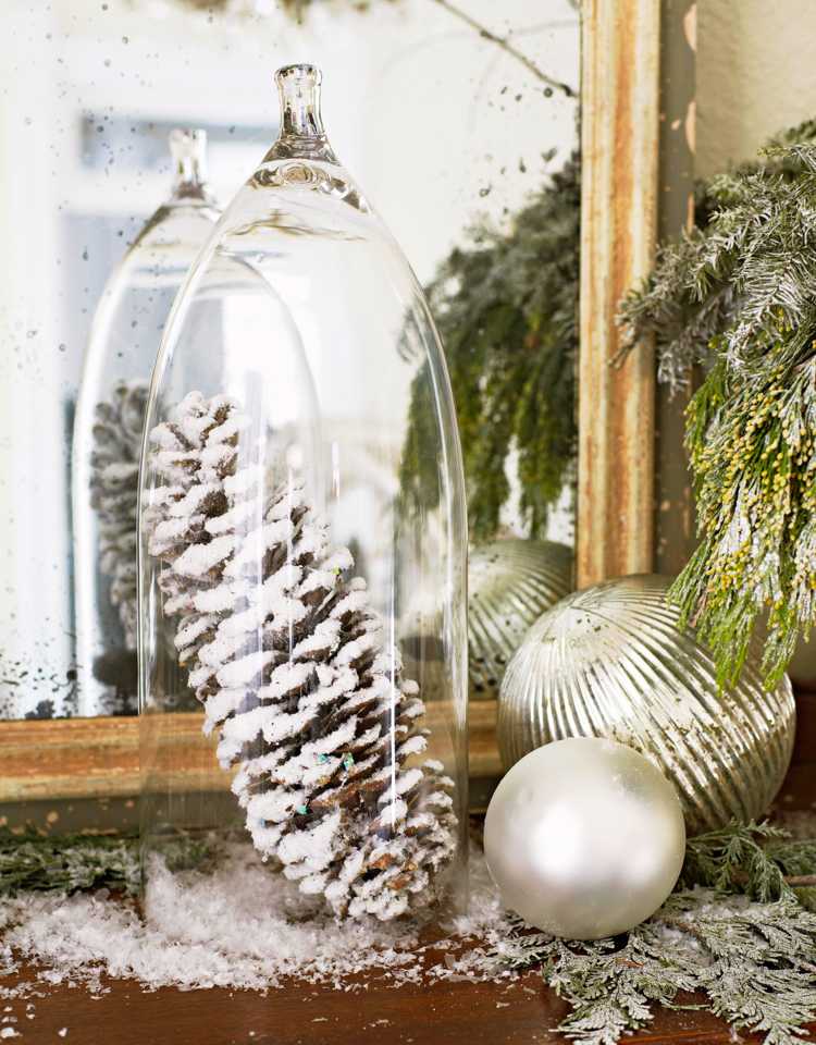 Spraya tallkottar med konstsnö, lägg under en glaskåpa och gör juldekorationer i stil med vinterunderland