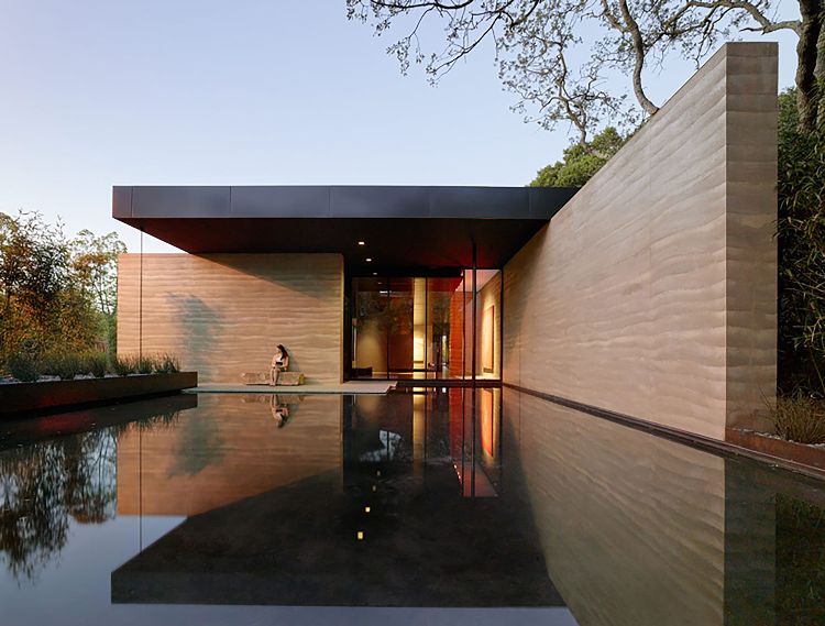 byggnad med ramad jord hybridmaterial modern arkitektur innergård vatten