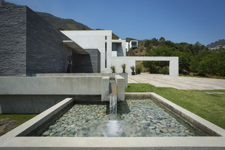 hus i bauhaus-stil-granit-betong-trädgård-gräsmatta-vatten-kaskader