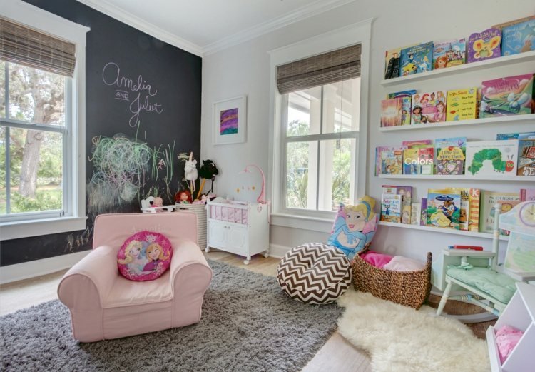 Flickrum med en tavla och en läshörna med massor av böcker på väggen