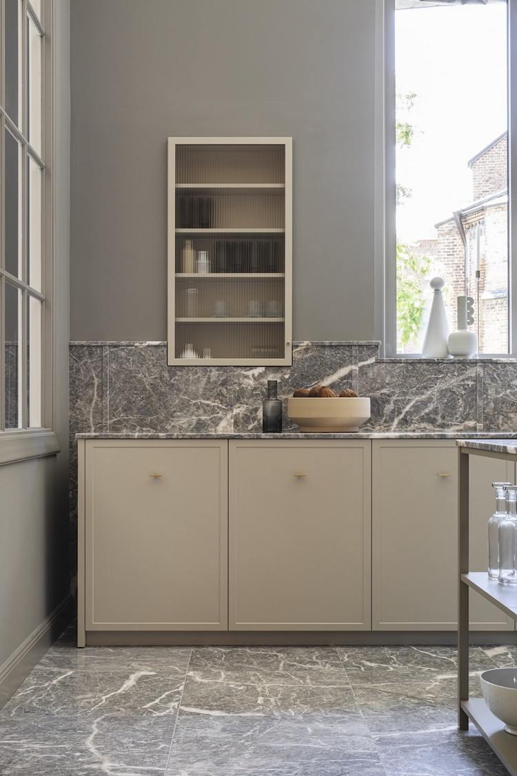 Beige kök och grå väggfärg och bänkskiva i marmor