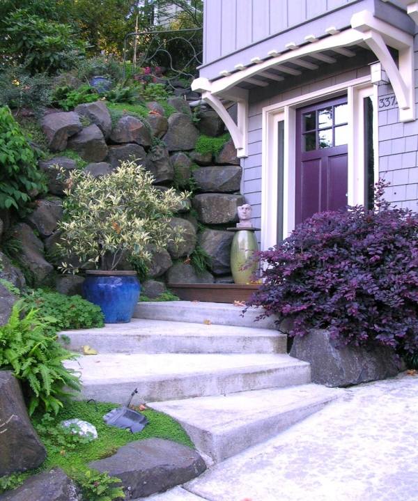 exempel på trädgårdsdesign trappor buske lila stenmur