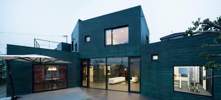 betong-arkitektur-exponerad betong-hus-platt-tak-grönt-panorama-fönster