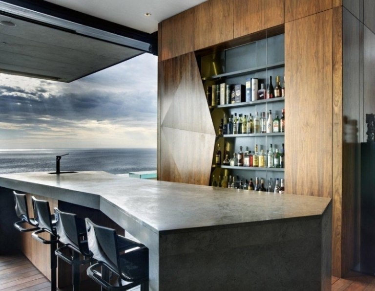 betong-design-modern-bar-flaskor-mot-pall-trä-fönster framåt havsutsikt