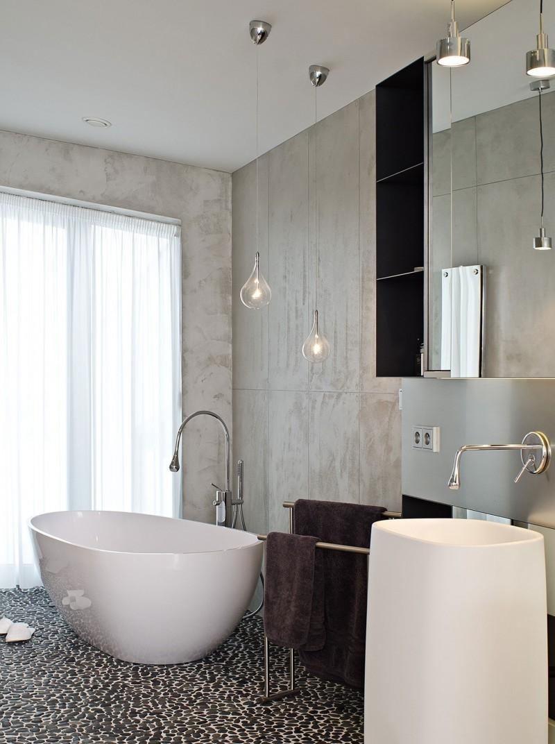 betong-design-modernt-badrum-fristående-badkar-vit-svart-tvätt-konsol-matta-kran-spegel-skåp