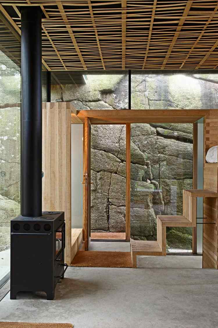 Betong och glas -hus-interiör-vedeldad spis-trä-tak-paneler-trappsteg