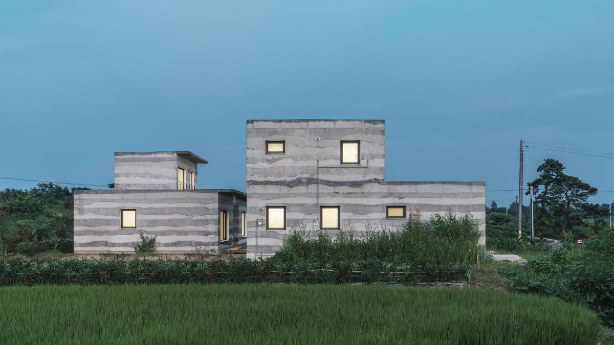 Bygg ett lagerhus av betonghus som liknar en gräddtårta med små fönster och en trädgård