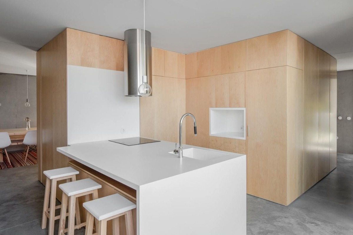 designerkök med en vit köksö i en kombination av trä och betong