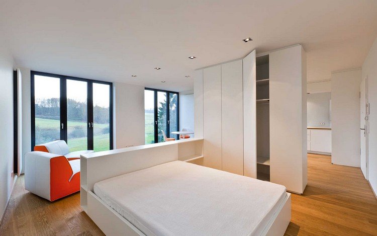 en-rums-lägenhet-öppen planlösning-säng-sänggavel-hyllor-garderob