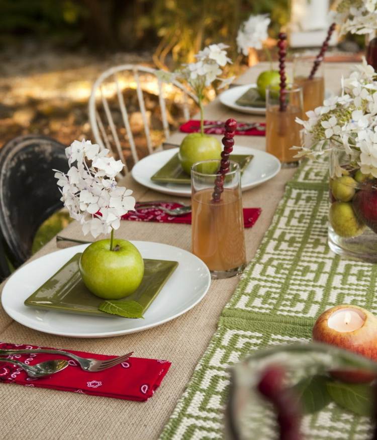 bordsdekoration i höstens äpplen idé grön bordslöpare röda servetter vita blommor