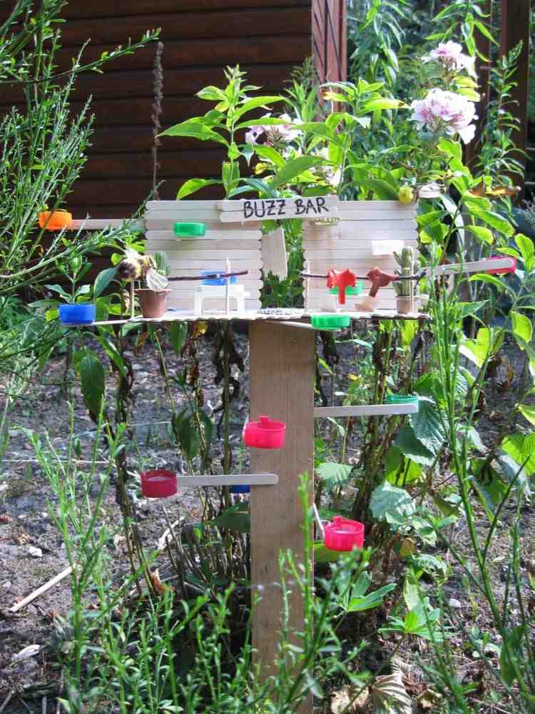 Gör ett insekttåg själv med barn med ispinnar och flasklock