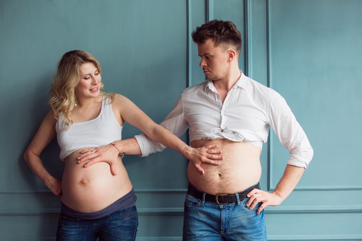 gravid fru och hennes man jämför sina mage med händerna kan bli av med ölmagen