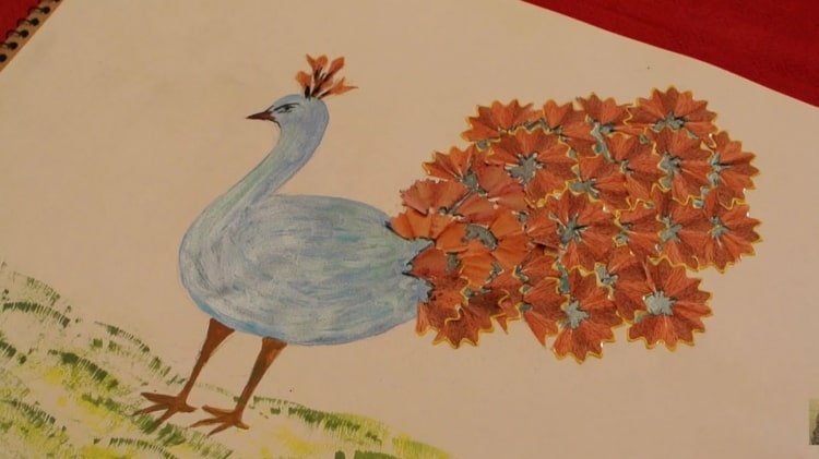 Idé för en självmålad påfågel med svansfjädrar gjorda av färgpennspån
