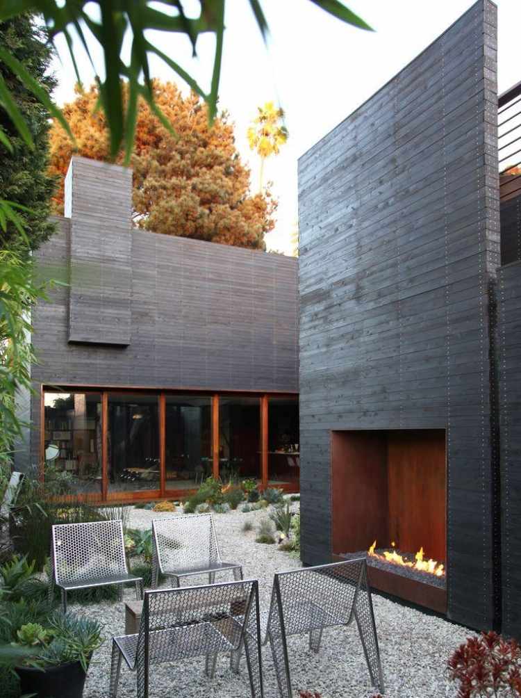 bioetanol-öppen spis-vägg-installation-modern-utomhus-grus-stolar-metall-perforerad plåt-cortnestahl-väggbeklädnad-trä lameller