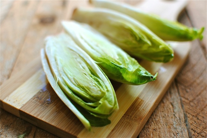 endivblad salladsväxter blekning av sallad som förbereder träskiva