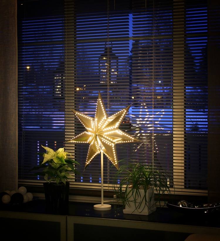 vit julstjärna och LED -stjärna på fönsterbrädan