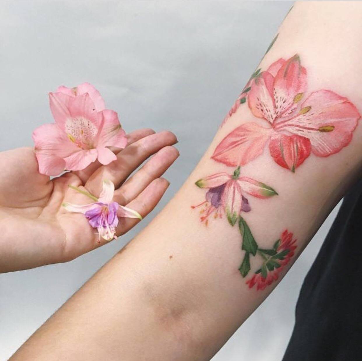 Blomma tatuering överarm liten akvarell tatuering trend