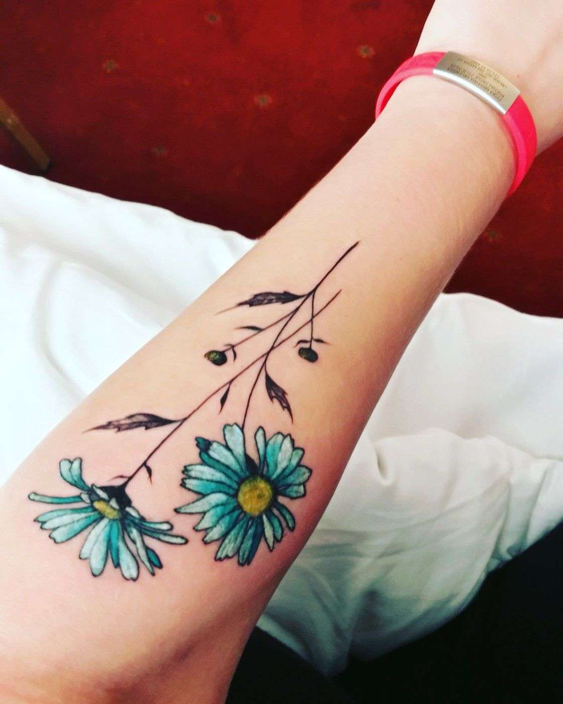 Tusenskönor blomma tatuering underarm små minimalistiska tatueringstrender