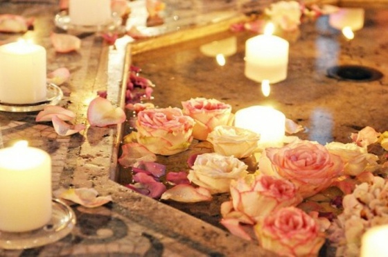 Natursten-golv-med-tända-ljus-och-ros-blommar
