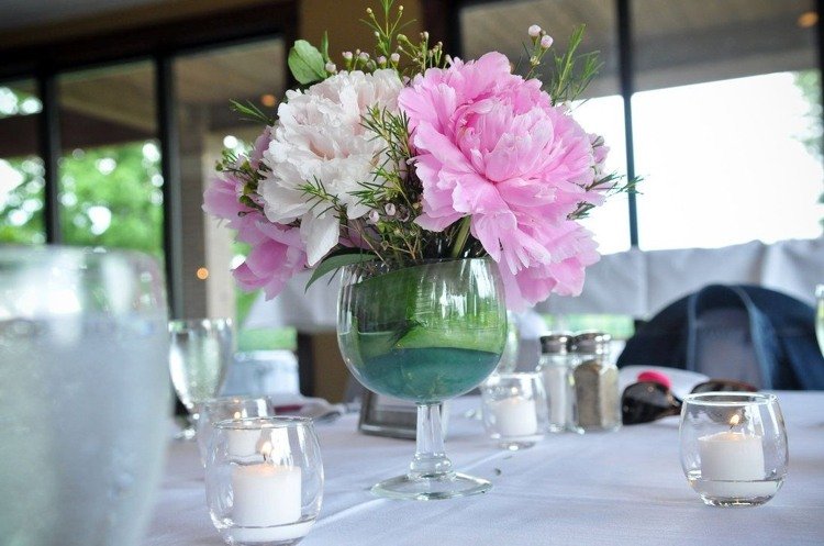 Blomsterdekorationer i vinglaset, rosa ton-i-ton, blomsterarrangemang, pioner, liljekonvaljer