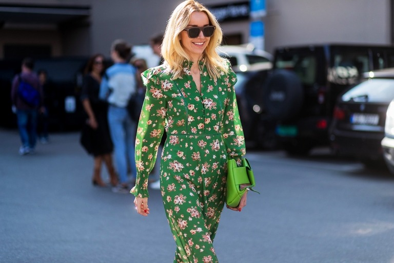 Blommig jumpsuit grön handväska ljusblont hår kombinerar de senaste modetrenderna