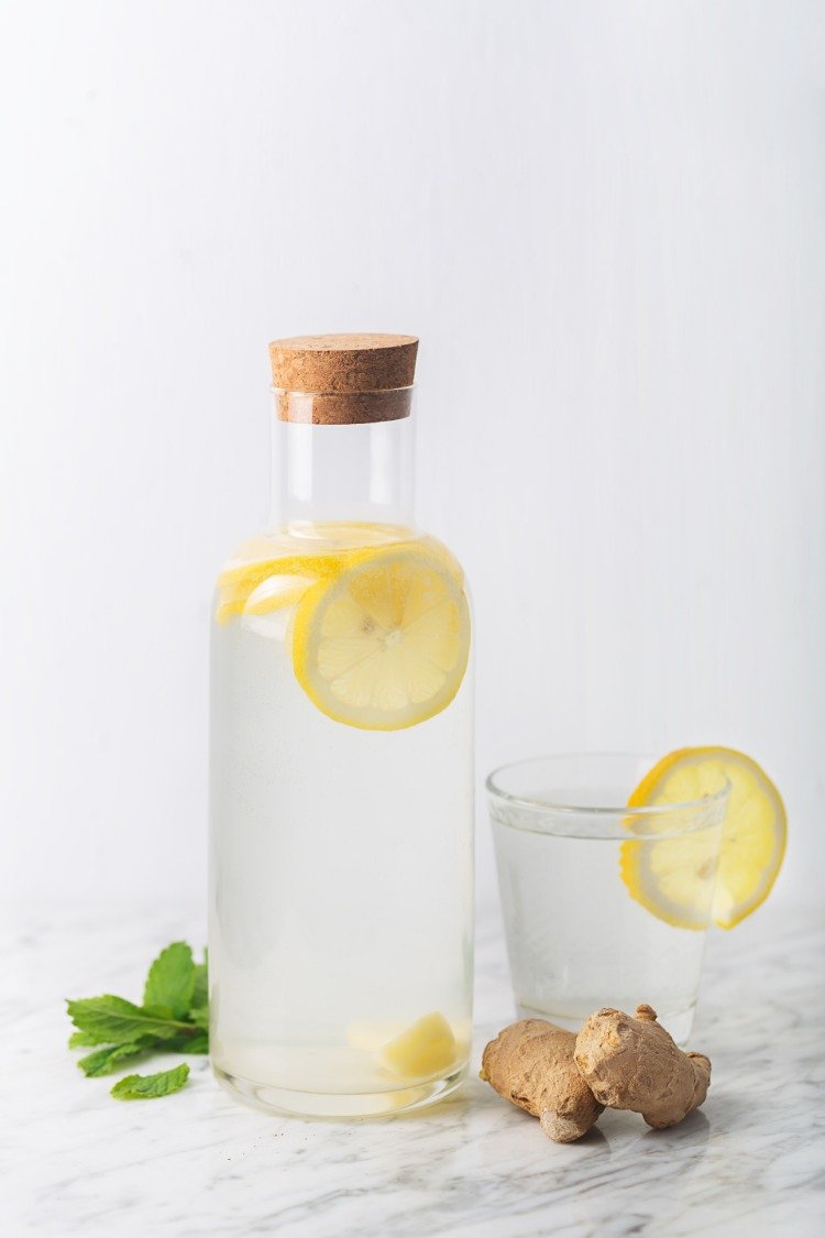 glas och flaska med vatten citron ingefära och mynta