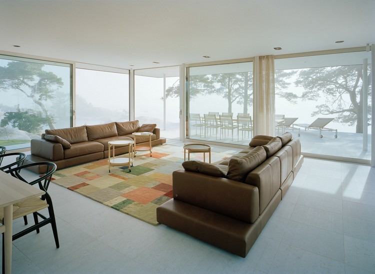 golv till tak fönster villa privat ö vardagsrum lädersoffor brun