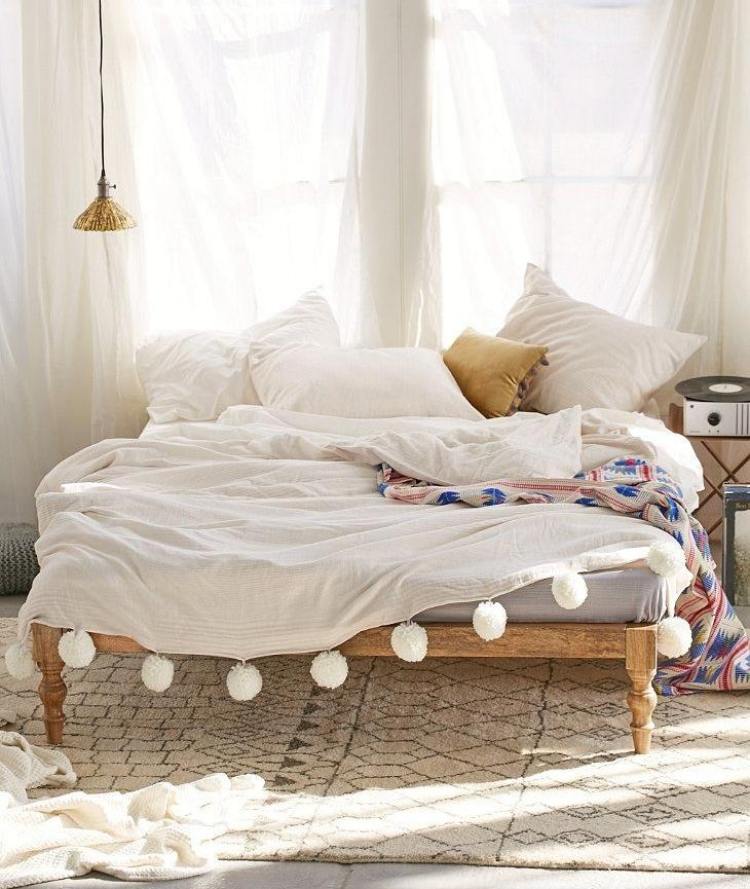 bohemisk stil-sovrum-vit-trä säng-pomponger-kuddar-gardiner-bomull