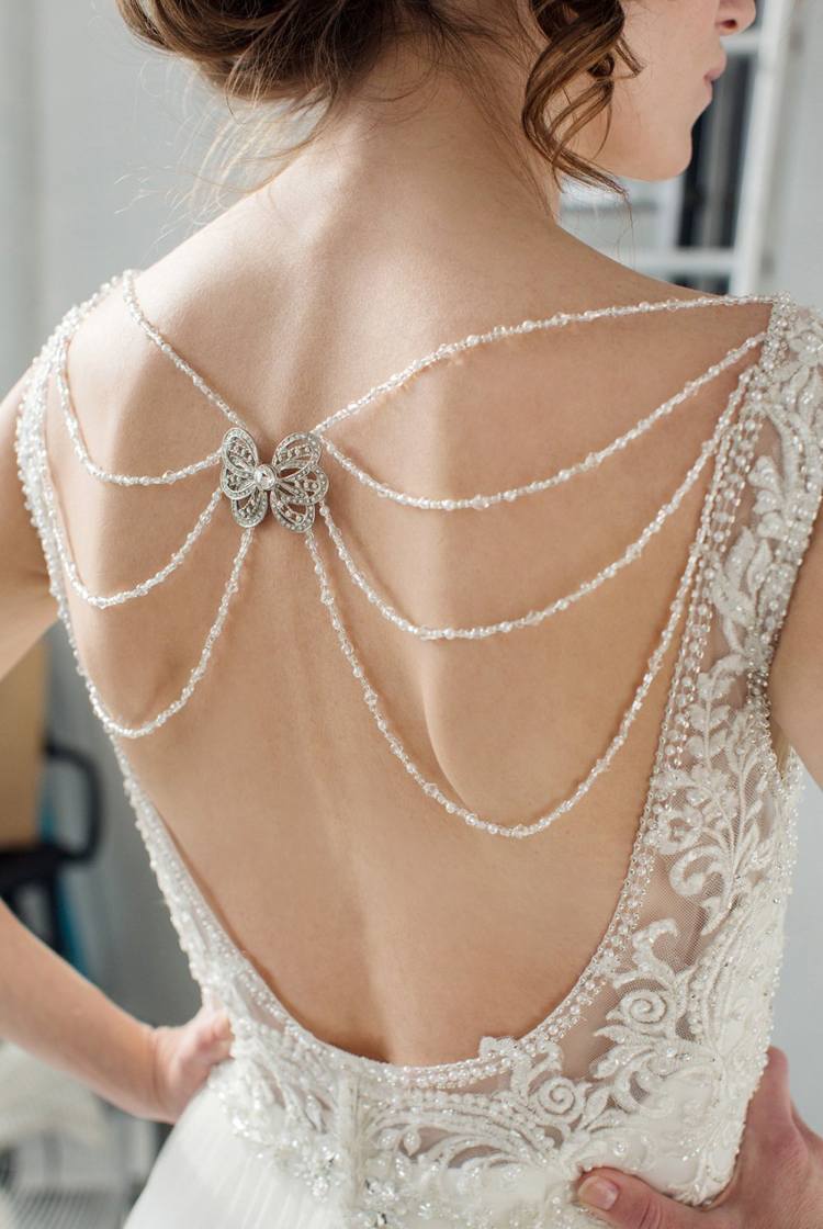 Bröllopsklänning rygglösa pärlhalsband brosch accentuerad på baksidan