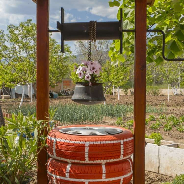 Brick-look fontän gjord av bildäck med en gammal metallhink för plantering