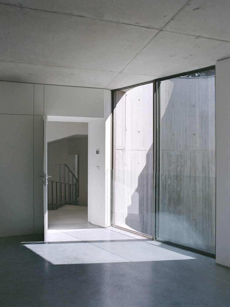 Modern inredning gjord av exponerad betong och glasdörrar