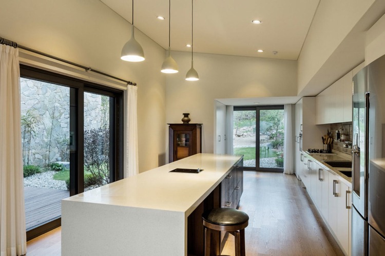 bungalow-hus-natursten-modernt-vardagsrum-kök-vitt-minimalistiskt