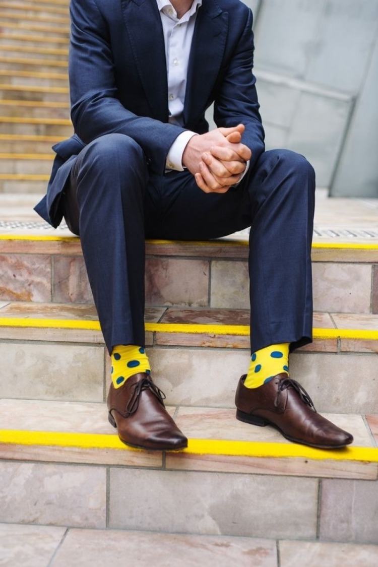 blå kostym kombinerar bra med gula strumpor och bruna oxfordskor