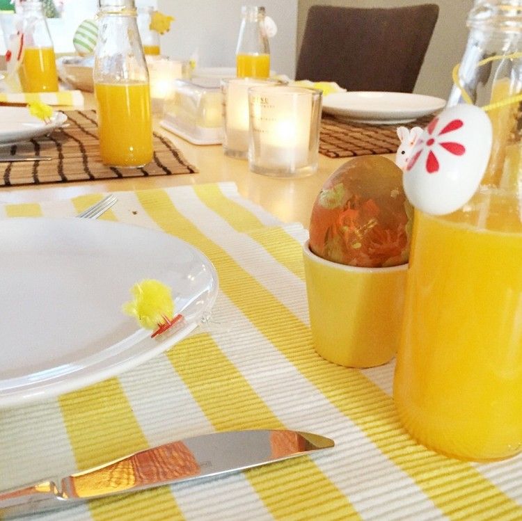 bordsdekoration-påsk-gul-vit-dekorationer-apelsinjuice-målade-ägg-äggkoppar