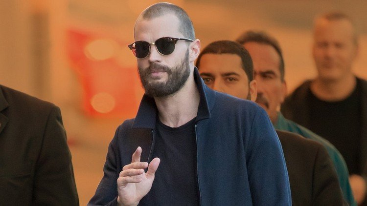 jamie dornan kort frisyr med tre dagars skägg och jacka med t -shirt och solglasögon